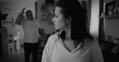 Kadın hararetli tartışmalar sırasında yüzünü geri çeviriyor. Arka plandaki adam duygusal hareketler yapıyor. Gerilime ve gergin ilişki dinamiklerine odaklanıyor.