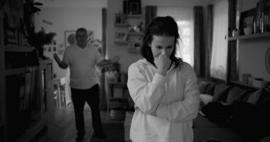 Kadın hararetli tartışmalar sırasında derin düşüncelere dalarken, arka plandaki erkek hayal kırıklığı, gerginlik ve bir çiftin ilişkilerindeki çözülmemiş sorunları işaret ediyor.