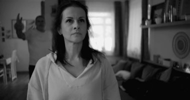 Kadın hararetli tartışmalar sırasında yüzünü geri çeviriyor. Arka plandaki adam duygusal hareketler yapıyor. Gerilime ve gergin ilişki dinamiklerine odaklanıyor.