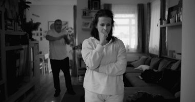 Kadın hararetli tartışmalar sırasında derin düşüncelere dalarken, arka plandaki erkek hayal kırıklığı, gerginlik ve bir çiftin ilişkilerindeki çözülmemiş sorunları işaret ediyor.