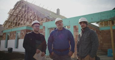 İnşaat ekibi inşaat alanının planlarını, takım çalışmasını ve koordinasyonunu, proje detayları, yönetim ve inşaatta planlama üzerine çalışan profesyonelleri tartışıyor