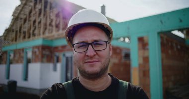 İnşaat işçisi inşaat alanında kollarını kavuşturmuş, inşaat sektöründe kendine güvenen, sorumluluk sahibi ve gururlu bir inşaat işçisi, devam etmekte olan bir proje.