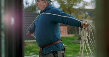 İnşaat sahasında miğferi olan işçilere kablo taşıyıp düzenlemek, el işçiliği ve dışarıda profesyonel aktiviteler sergilemek.