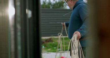 İnşaat sahasında miğferi olan işçilere kablo taşıyıp düzenlemek, el işçiliği ve dışarıda profesyonel aktiviteler sergilemek.