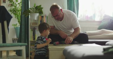 Baba, kahve masasında oyuncak tren oyunu oynayan çocukla karşılaşır. Baba ve oğul arasında samimi bir bağ kurar. Sakin ve sıcak bir oturma odası kurar.