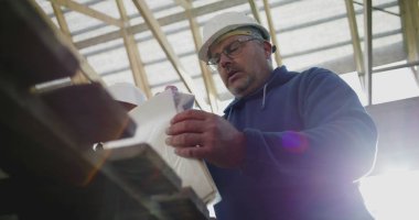 İnşaat denetçisi inşaat planlarını gözden geçirirken aynı zamanda inşaat çalışanı, takım çalışması ve yapısal proje rehberliği, güvenlik kaskları takılı