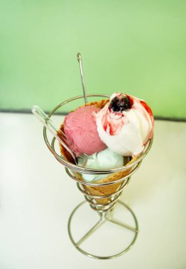 Dondurma sahipleri. Çilek, nane, vanilya ve vişne dondurma büyük gözleme koni tutucu, kaşık. Taze pişmiş dondurma waffle koni gümüş sandalyesinde oturuyor. Dondurma dükkanı. Pastane.