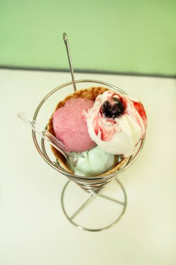 Dondurma sahipleri. Çilek, nane, vanilya ve vişne dondurma büyük gözleme koni tutucu, kaşık. Taze pişmiş dondurma waffle koni gümüş sandalyesinde oturuyor. Dondurma dükkanı. Pastane.