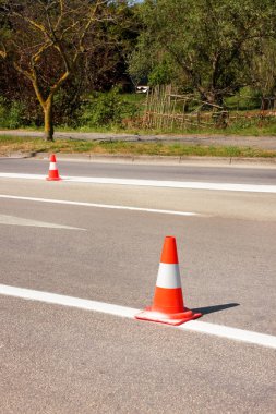 Yol üzerinde çalışması. İnşaat külah. Trafik koni, asfalt üzerinde beyaz ve turuncu çizgili. Sinyal için ev ve trafik işaretleri. İnşaat işareti ve trafik konileri yolda altında yol bakım.