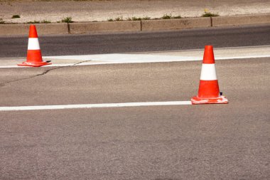 Yol üzerinde çalışması. İnşaat külah. Trafik koni, asfalt üzerinde beyaz ve turuncu çizgili. Sinyal için ev ve trafik işaretleri. İnşaat işareti ve trafik konileri yolda altında yol bakım.