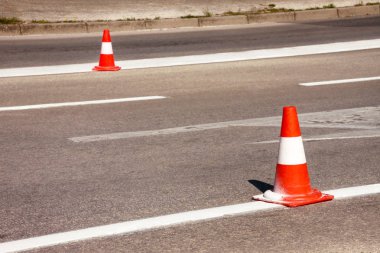 Yol üzerinde çalışması. İnşaat külah. Trafik koni, asfalt üzerinde beyaz ve turuncu çizgili. Sinyal için ev ve trafik işaretleri. İnşaat işareti ve trafik konileri yolda altında yol bakım.
