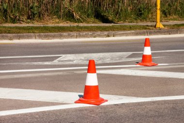 Yol üzerinde çalışması. İnşaat külah. Trafik koni, asfalt üzerinde beyaz ve turuncu çizgili. Sinyal için ev ve trafik işaretleri. İnşaat işareti ve trafik konileri yolda altında yol bakım.