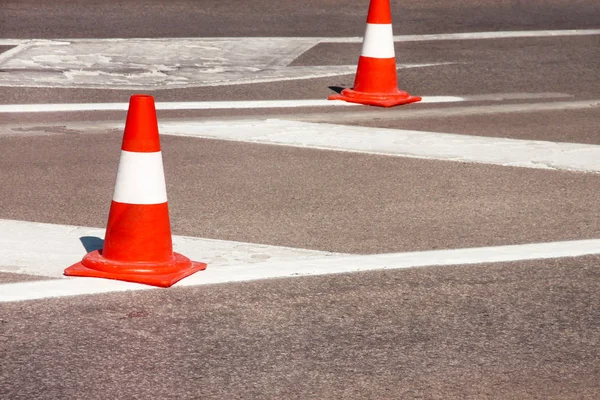 Yol üzerinde çalışması. İnşaat külah. Trafik koni, asfalt üzerinde beyaz ve turuncu çizgili. Sinyal için ev ve trafik işaretleri. İnşaat işareti ve trafik konileri yolda altında yol bakım.
