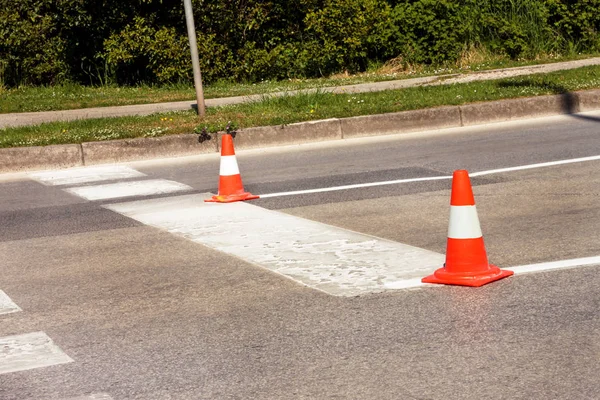 Yol üzerinde çalışması. İnşaat külah. Trafik koni, asfalt üzerinde beyaz ve turuncu çizgili. Sinyal için ev ve trafik işaretleri. İnşaat işareti ve trafik konileri yolda altında yol bakım.