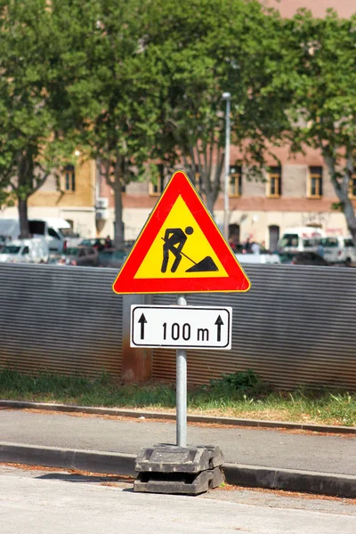 Road works sign for construction works in city street. Road under construction traffic sign. Traffic, warning sign road repairing. Outdoor street sign. Red, black and yellow triangle road sign work.