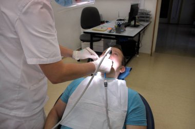 Diş diş parlatma. Diş temizliği, diş temizliği. Dişçi Diş Kliniği ve office iş araçları ayna, yumuşak diş fırça ve emme borusu ağzına hasta diş parlatma.