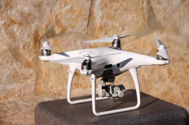 Beyaz quadcopter dron stand 4 k dijital kamera ile fotoğraf çekmek, görüntüleri yukarıdan kayıt için havada uçmaya kalkış için hazır. Dört motorlar, pervaneleri, kamera ve kırmızı uyarı lambaları ile robot.