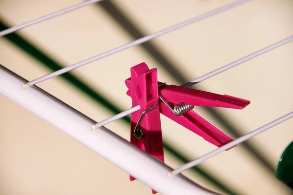 Cloth Clothespins on drying rack, selective focus. Colorful plastic clothespins on clothesline. A lot of multicolored wool cloth clamps attached the rope. Plastic color clothespin hanging on a wire.