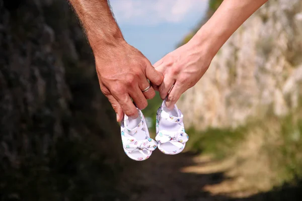 Hamile kadın ve bebek patiği elinde tutan adam. Gelecekte anne ve baba, anne küçük yeni doğan bebek patiği tutarak. Doğum beklenti kavramı. Bebek bekliyor. Hamile kadın, gebelik, annelik.