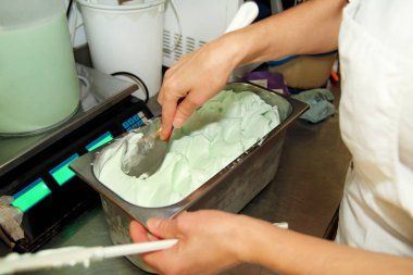 Pudra Şef üniforma içinde dondurma fabrikasında çalışıyor. Süslemeleri İtalyan krem nane dondurma tatlar çelik kap içinde bir kadındır. Üretim, sanayi, üretim, insanlar kavramı.