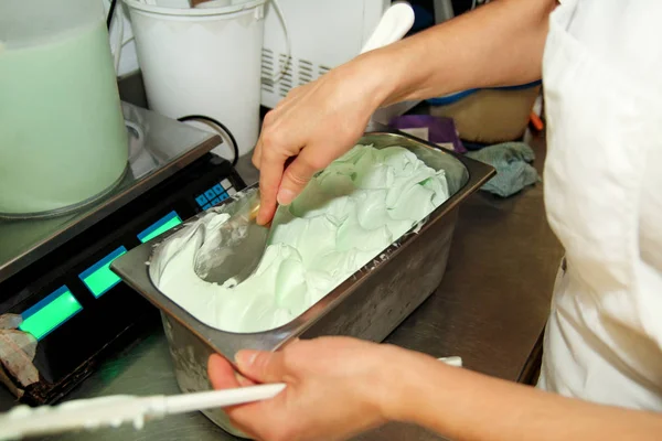 Pudra Şef üniforma içinde dondurma fabrikasında çalışıyor. Süslemeleri İtalyan krem nane dondurma tatlar çelik kap içinde bir kadındır. Üretim, sanayi, üretim, insanlar kavramı.