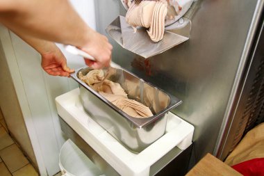 Pudra Şef üniforma içinde Ice cream maker makina üzerinde çalışıyor. Kadın fındık aromalı dondurma üreten, çelik kap içine düşüyor. İtalyan kremalı dondurma endüstriyel hazırlanması.