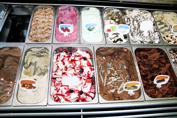 Ice cream fridge with creamy and fruit Italian ice cream steel serving counter with many of refreshing sweet scoopable flavors. Ice cream display, various flavors of gelato ice cream. Pastry shop.