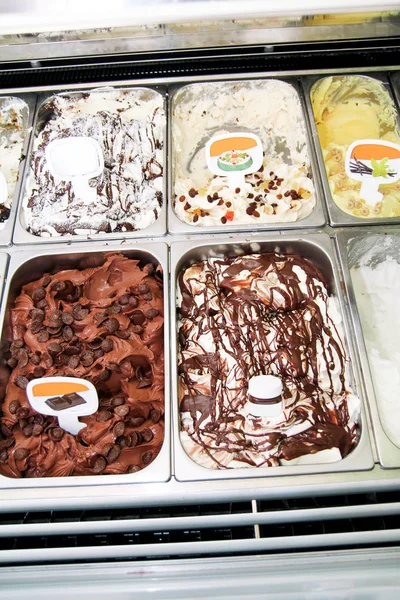 Ice cream fridge with creamy and fruit Italian ice cream steel serving counter with many of refreshing sweet scoopable flavors. Ice cream display, various flavors of gelato ice cream. Pastry shop.