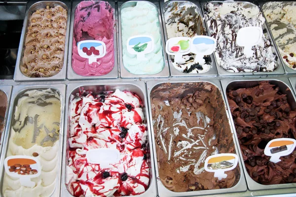 Ice cream fridge with creamy and fruit Italian ice cream steel serving counter with many of refreshing sweet scoopable flavors. Ice cream display, various flavors of gelato ice cream. Pastry shop.