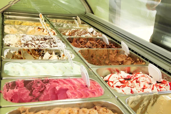 Ice cream fridge with creamy and fruit Italian ice cream steel serving counter with many of refreshing sweet scoopable flavors. Ice cream display, various flavors of gelato ice cream. Pastry shop.