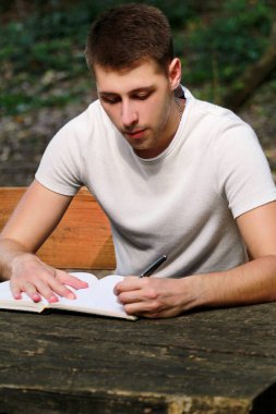 Kitap, defter, öğrenme ve yazar düşünceler, adam ve öğrenci alır notlarda yazıyor o ödev yapmak ve düşünmek onun sınavları hazırlanıyor. Adam bir şey defterindeki çiziminden ormandaki yazıyor.