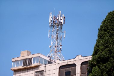 Telekomünikasyon Bankası ağ tekrarlayıcılar binanın çatısında istasyonları. Hücresel iletişim hava şehri çatı bina üzerinde. Cep telefonu telekomünikasyon Kulesi. Binanın üstüne antenler.