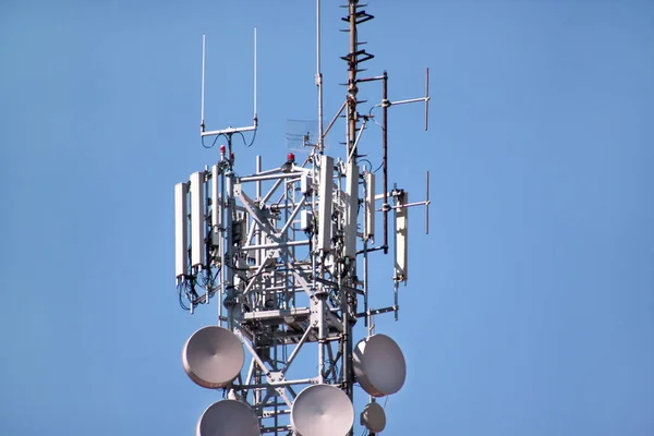 Telecommunication network repeaters, base transceiver station. Tower wireless communication antenna transmitter and repeater. Telecommunication tower with antennas. Cell phone telecommunication tower.