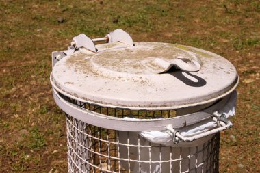 Çöp ve Geri Dönüşüm Kutusu'na doğal güneşli günde açık park. Çöp geri dönüşüm olabilir ve bin beyaz plastik torba ile çöp kutusu. Çöp konteyner ayakta kaldırımda. Çöp çöp sürü ile bu.