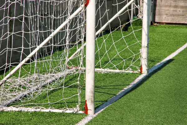 部分足球球门门与白网 在足球场与绿草和体育场 白线和足球场角的足球场上近距离发展 体育元素 设备和环境 — 图库照片