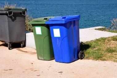 Çöp Kovası, çöp kutusu, depo gözünde turist karmaşık deniz, çöp kamyonu tarafından alınmayı bekleyen yolun tarafından geri dönüşüm. Sıralama, sıralama çöp kağıt ve cam atıklar için mavi ve yeşil kapları.