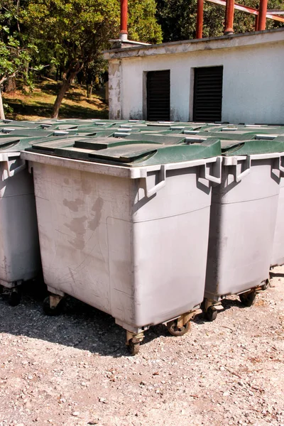 Large garbage containers, trash dumpsters and bins standing in row. Orderly stowed garbage cans ready for separate garbage collection. Environmentally friendly trash containers, recycle bins, tanks.