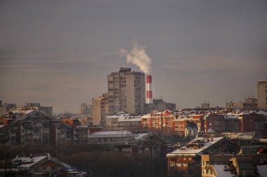 Sigara içerken ısıtma tesisi, sınaî bacaları duman, gün batımında smog City yayar, kirleticilerin atmosfere girmek. Çevre felaketi. Zararlı emisyonların, egzoz gazı havaya. Isıtma sezonu.