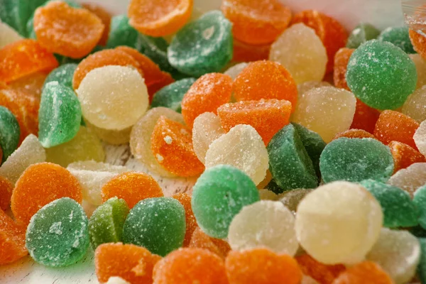 Different gelatin sweet fruit candy candies sugar. Assorted colorful jelly sweets. Colored confectionery for kids. Delicious multicolor candies in box. White, green, orange, yellow color background.