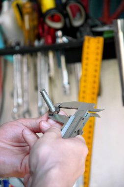 İşçi elinde araçlarıyla. Mekanik kontrol ve vida boyutu paslanmaz çelik gövde automechanics atölye, araç garaj ile ölçme. Çelik gövde kullanarak eller mekanik holding çelik vida.