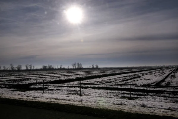 Karayolu kış manzara çayırlar ve kar tabakası ile kaplı alanlar üzerinden görüntüleyin. Mavi gökyüzü ve güneş ile inanılmaz doğal çevre. Kışın mevsim belirli karla kaplı güzel manzara.