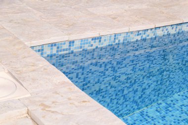 Mavi sökük su kaldırım kenarına tropikal Resort yüzme havuzunda. Yüzme Havuzu alt arka planın parçası. Açık ışık mavi havuz suyu güneş yansıması ile dalgaların. Yüzey Yüzme Havuzu.