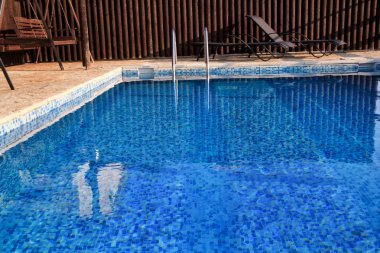 Yüzme Havuzu tasarım modern mimarinin lüks tatil Villa. Egzotik yüzme havuzuyla Küpeşte, şezlong, şezlong ve şemsiye tropikal resort otel turist bekliyor yakınındaki sakin ol.