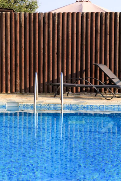Conception de piscine architecture moderne de villa de vacances de luxe. Détendez-vous près de la piscine exotique avec rampe, chaises longues, chaises longues et parasols attendant les touristes dans un hôtel de villégiature tropicale . — Photo