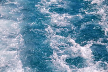 Türbülans deniz yüzeyi yüksek hızlı bir yat deniz suyu köpük tarafından yapılmış. Mavi deniz dalgaları ile deniz köpüğü çok. Dalgalar, sıçrama, köpük ve kabarcıklar, mavi arka plan ve duvar kağıdı ile deniz yüzeyine.