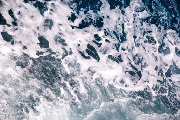 Turbulentie gemaakt door schuim van het zeewater van een snelle jacht op de oppervlakte van de zee. Blauwe zee golven met veel schuim van de zee. Oppervlakte van zee met golven, splash, schuim en bubbels, blauwe achtergrond en behang. — Stockfoto