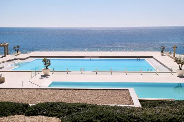 Doğa inanılmaz lüks tatil Otel'in havuz peyzaj Deniz Manzaralı. Küpeşte, şezlong, şezlong ve şemsiye tropikal tatil turist bekleyen ile iki yüzme havuzu yakınındaki sakin ol.