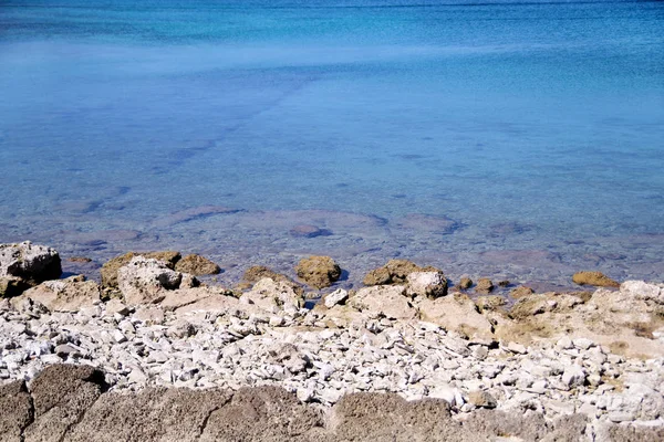 Playa rocosa exótica, mar mediterráneo tropical azul con olas y espuma de mar. Hermoso entorno natural, panorama, paisaje. Idílico balneario en temporada de verano, paraíso y escena increíble . —  Fotos de Stock