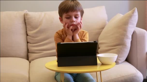 Criança Usando Tablet Cama Casa Garoto Bonito Sofá Está Assistindo — Vídeo de Stock