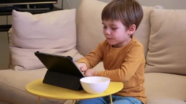 Criança Usando Tablet Cama Casa Garoto Bonito Sofá Está Assistindo — Vídeo de Stock